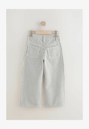 Striped wide-leg trousers hung on a wooden hanger, featuring a white background with thin black vertical stripes and two back pockets.