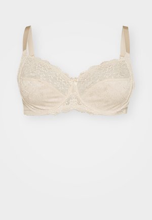 Beige lace bra with floral pattern, underwire support, adjustable satin straps, and a small central bow detail. Soft, textured fabric.