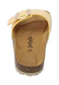 Sandal giallo con cinturino regolabile e fibbia argentata. Sottopiede in sughero beige, superficie testurizzata e suola bianca. Logo del marchio visibile all'interno.