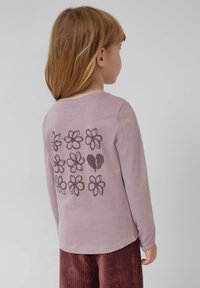 Lila langpoloshirt met een bloemenpatroon en een gebroken hart ontwerp op de rug, vervaardigd uit zachte katoen.