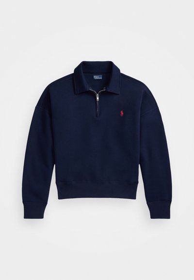 Pulover închis la culoare, cu fermoar la gât, realizat din bumbac moale, având guler, manșete și tiv cu model în relief, decorat cu un mic logo roșu pe piept.