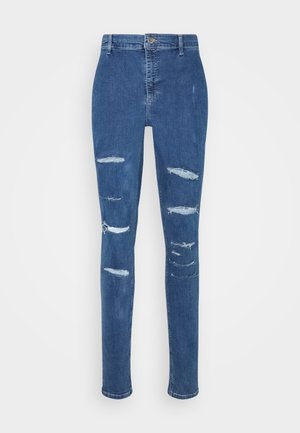 Jeans in denim blu con vestibilità slim, caratterizzati da diverse zone rovinate e una finitura leggermente sbiadita. Design classico a cinque tasche e chiusura con bottone.