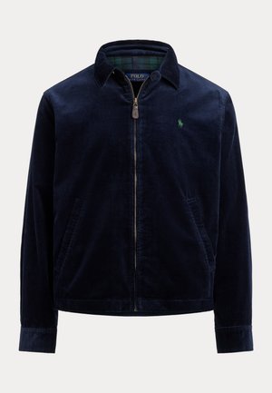 Navy blue corduroy jacket with a zippered front, collar, two side pockets, and a green embroidered logo on the chest. Textured fabric.