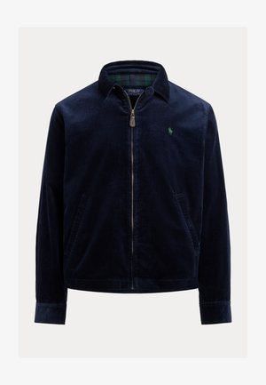 Veste en velours côtelé bleu marine avec fermeture éclair à l'avant, col, deux poches latérales et un logo brodé vert sur la poitrine. Tissu texturé.