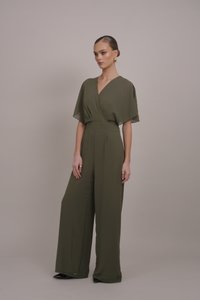 Olíva zöld, bőszárú overall rövid kimono ujjakkal, elöl átkötős kialakítással és megkötött derékrésszel. Sima textúra, minimalista stílus.