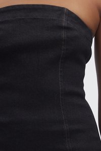 Sorte denim strapless kjole med en figursydd design, buet halsutskjæring og synlige sømdetaljer på siden. Jevn tekstur.