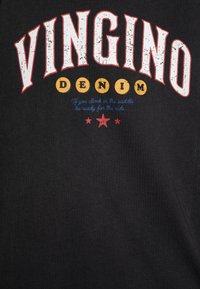 Svart bomull T-skjorte med iøynefallende hvite, røde og gule grafikker. Teksten inkluderer "VINGINO DENIM" og en blå slagord med stjerner under.