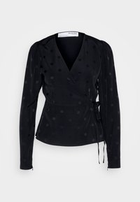 Černá zavinovací blusa z lehkého materiálu s vyvýšenými černými puntíky, dlouhými rukávy s nařasenými rameny a detailem vázání v pase.