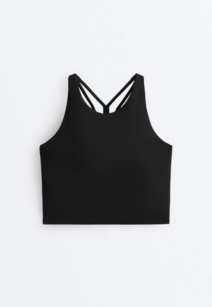 Black cropped sports tank top with thin double shoulder straps forming a V shape at the back on white background.