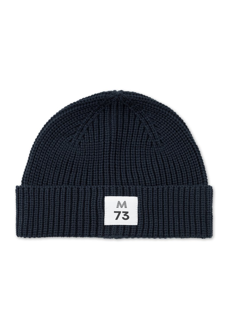 Tumesinine kudumüts, millel on sooniktekstuur, volditud äär ja valge silt, millel on musta värvi tekst "M 73".