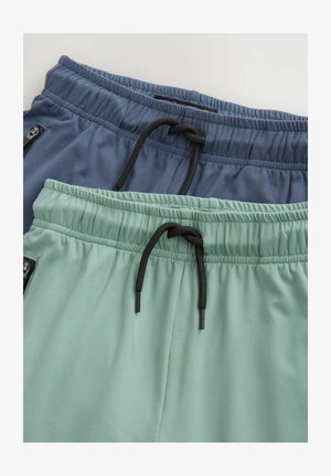 Divas divas sportisko bikses: vienas tumši zilas un otras piparmētru zaļas. Abām ir elastīgas jostas un saites aizdare. Gluda auduma tekstūra.