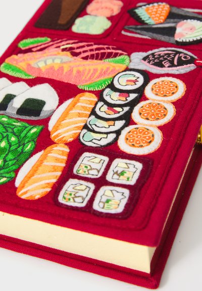 Czerwona okładka książki wyszywana różnorodnymi kolorowymi kawałkami sushi i rolkami ułożonymi w rzędy.