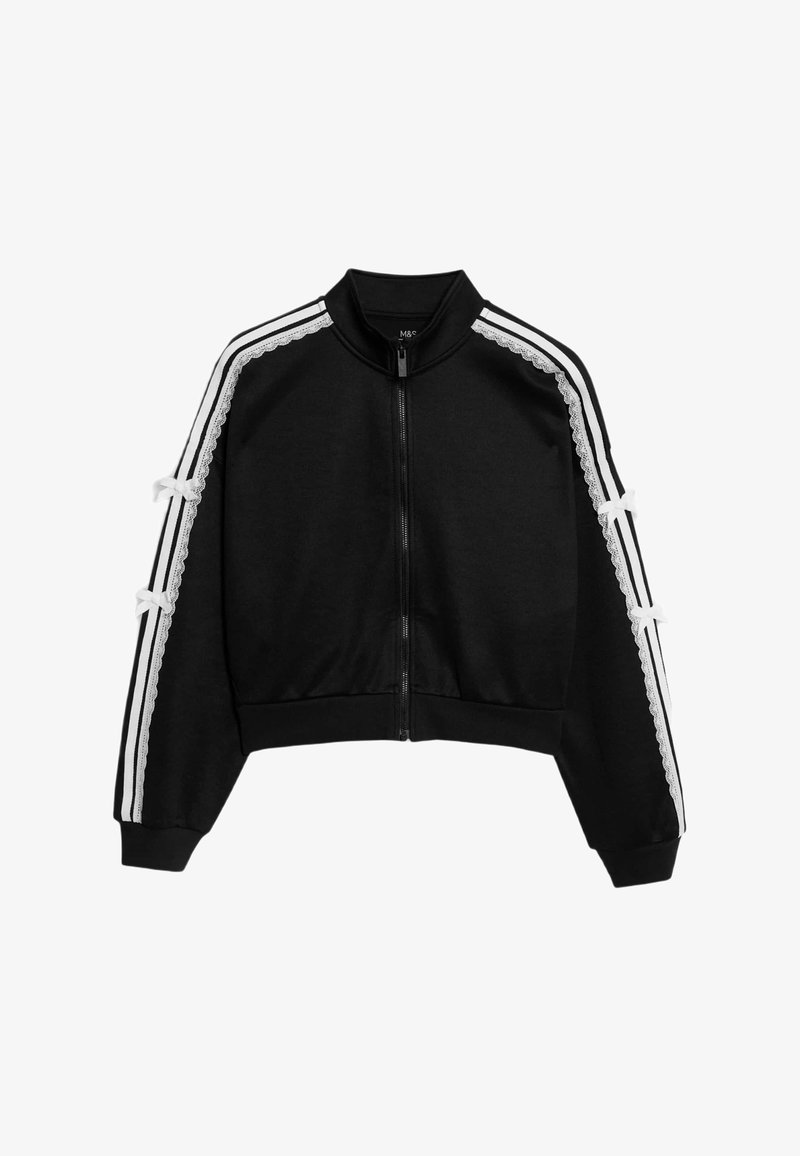 Černá zkrácená zipová bunda s bílými bočními pruhy a krajkovými detaily. Má měkkou látku a stužkové akcenty na rukávech.