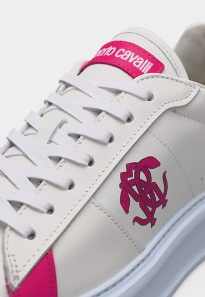 Λευκό αθλητικό παπούτσι με λευκά κορδόνια, ροζ λογότυπο στο πλάι και ροζ ετικέτα με την επιγραφή "roberto cavalli" στη γλώσσα.