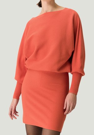 Robe tricotée côtelée corail avec un large col bateau, des manches longues et une silhouette ajustée, présentant un tissu texturé et un design sans couture.