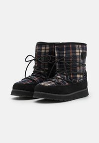 Bottines noires et à carreaux avec une tige en tissu doux, des accents en daim noir, des lacets ajustables et une semelle en caoutchouc texturée.