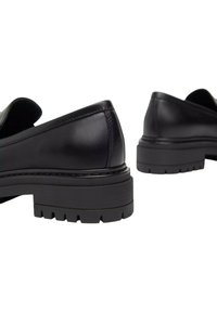 Mocassini in pelle nera con finitura liscia, punta rotonda e suola in gomma spessa con un motivo di battistrada robusto.