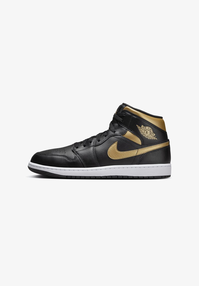 Sapatilha alta de couro preta com detalhes em dourado, apresentando uma sola branca, atacadores pretos e um logotipo distintivo na lateral.