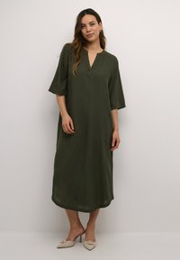 Vestido maxi verde caqui con cuello, mangas cortas, bolsillos laterales y silueta recta, hecho de tejido ligero.