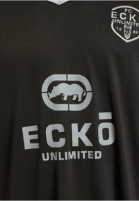 T-shirt de sport noir avec un col en V, présentant un grand texte ECKŌ UNLIMITED gris clair et un logo de rhinocéros centré au-dessus. Matériau en coton.