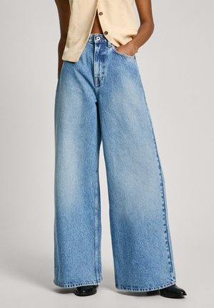 Jean en denim large couleur bleu clair avec taille haute, doté d'un design classique à 5 poches et de légers effets d'usure pour la texture.