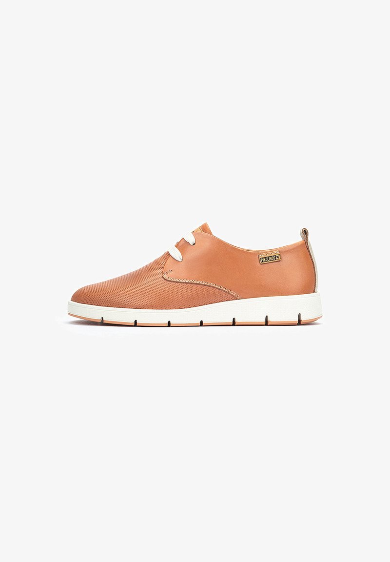 Zapatilla de cuero color marrón con diseño perforado, cordones blancos y suela blanca contrastante. Presenta una etiqueta de logo en el lateral.