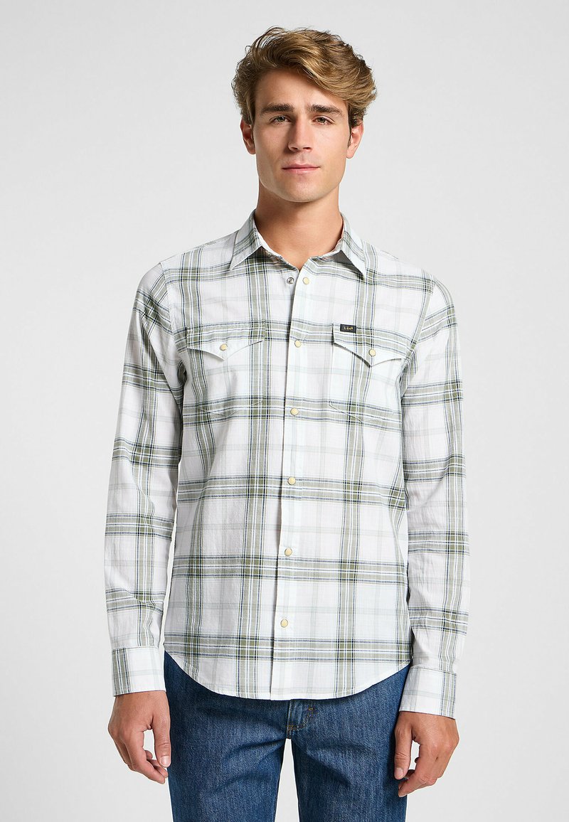 Camicia a maniche lunghe a quadri in bianco, verde e blu, con colletto a punta e due tasche sul petto. Tessuto morbido con chiusura frontale a bottoni.