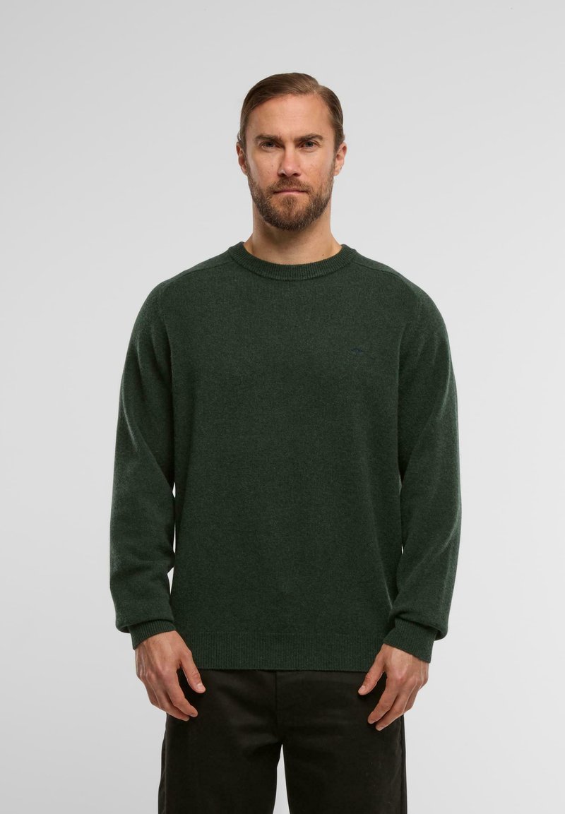 Pull en tricot vert à col rond, manches longues et bords côtelés, arborant un logo subtil sur la poitrine et une texture douce.