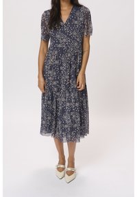 Marineblaues Blumenkleid mit gestuften Design, kurzen Puffärmeln und V-Ausschnitt. Hergestellt aus einem leichten, durchsichtigen Stoff mit cremefarbenen Blumenmustern.