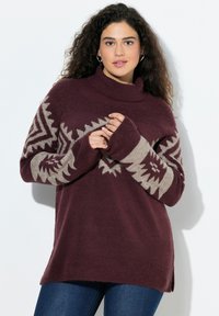 Burgunderfarbener Strickpullover mit hohem Kragen, der beige geometrische Muster an den Ärmeln aufweist. Weiche Textur, lockere Passform und seitliche Schlitze.