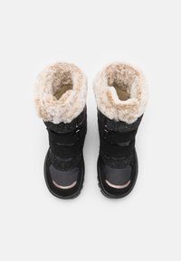 Bottes d'hiver noires avec bord en fausse fourrure, tissu noir texturé, sangles velcro, et un matériau synthétique brillant sur le orteil et la semelle.