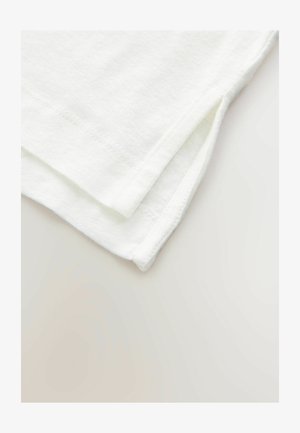 White cotton fabric folded neatly, featuring a clean edge seam with small side slits at the hem, displaying a soft texture.