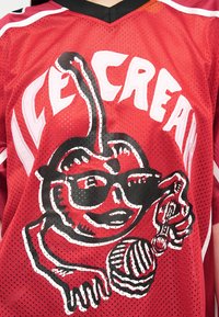 Κόκκινη αθλητική φανέλα με γραφικό ενός κερασιού που χαμογελάει, φοράει γυαλιά ηλίου, κρατάει ένα παγωτό σε χωνάκι και ένα κουτάλι, με το κείμενο «ICE CREAM» από πάνω.