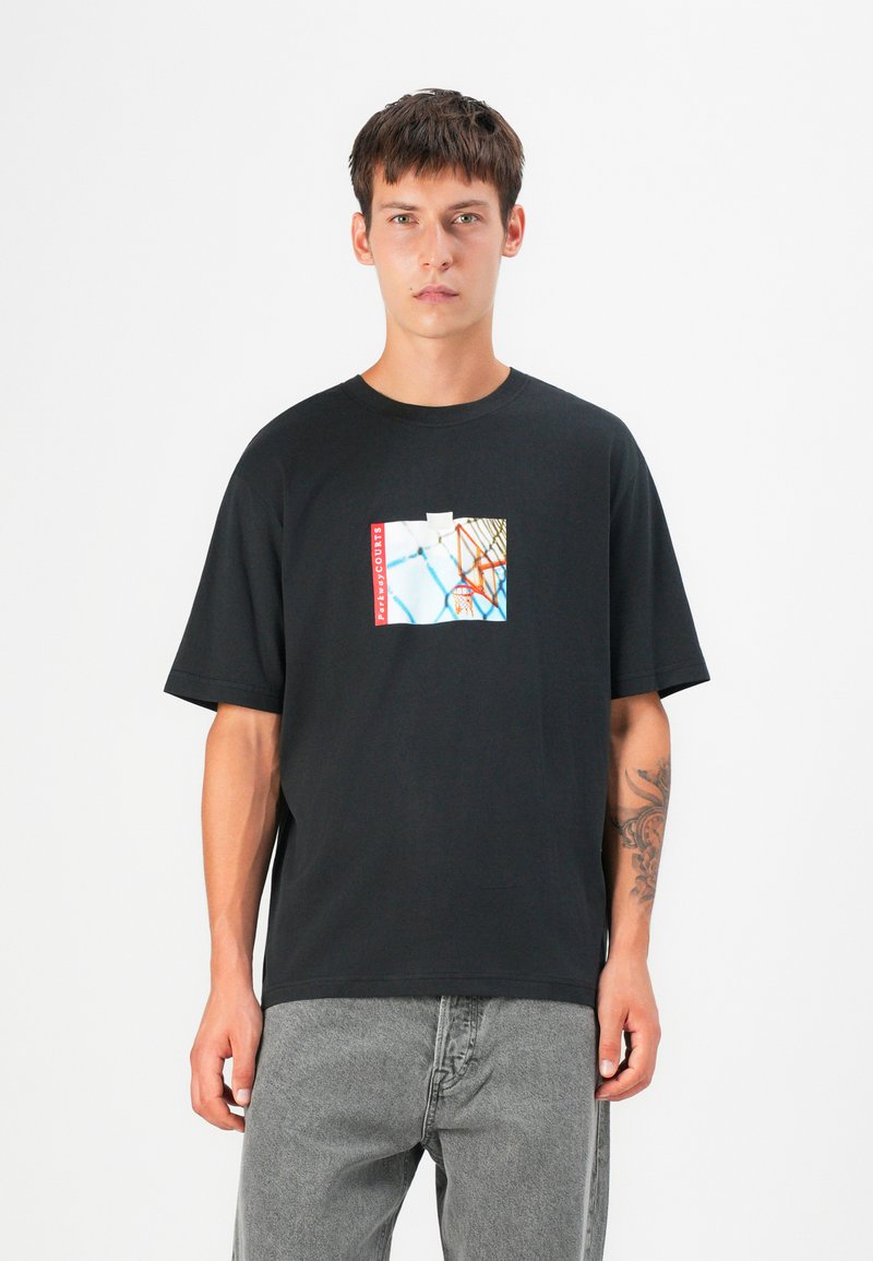 Black cotton t-shirt featuring a graphic print with blue, white, and red accents. It has short sleeves and a loose fit.