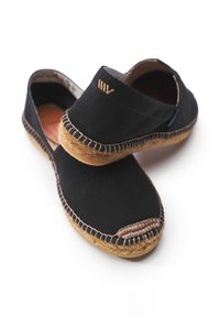 Black canvas espadrilles with woven jute soles, featuring a stitched edge and a small embroidered logo on the heel.