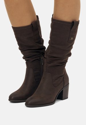 Bottes en tissu marron jusqu'au genou avec un design décontracté, des orteils ronds, des fermetures éclairs sur le côté et un talon épais. Comprend un petit accent de logo.