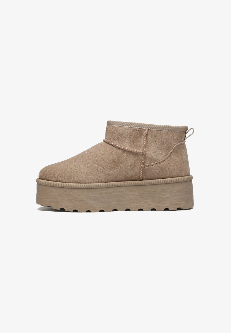 Beige mockask stövlett med rund tå, elastisk krage och tjock plattformssula med djupa spår för bättre grepp. Platt, strömlinjeformad design.
