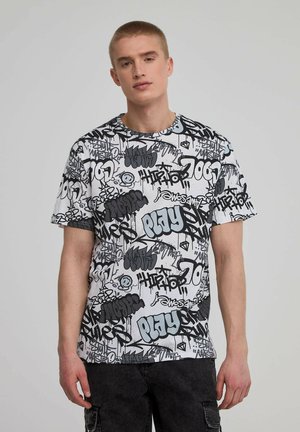 T-shirt a maniche corte con sfondo bianco coperto da testi e disegni in stile graffiti neri e blu. Vestibilità regolare e colletto a girocollo.