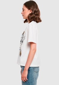 White cotton t-shirt with short sleeves, featuring a black and orange graphic illustration on the front. Classic round neckline and relaxed fit.