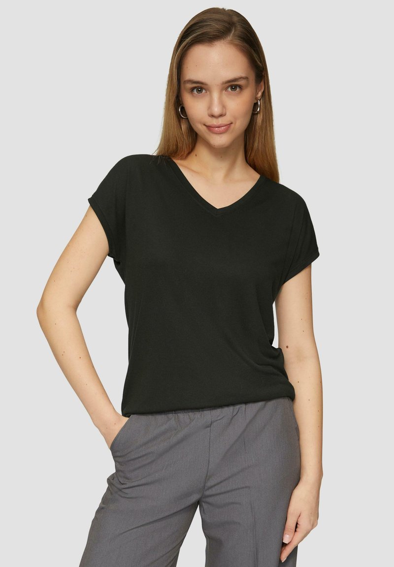 Czarny t-shirt z dekoltem w kształcie litery V i krótkimi rękawami, wykonany z miękkiego, lekkiego materiału; w połączeniu z szarymi spodniami. Gładka tekstura, luźny krój.