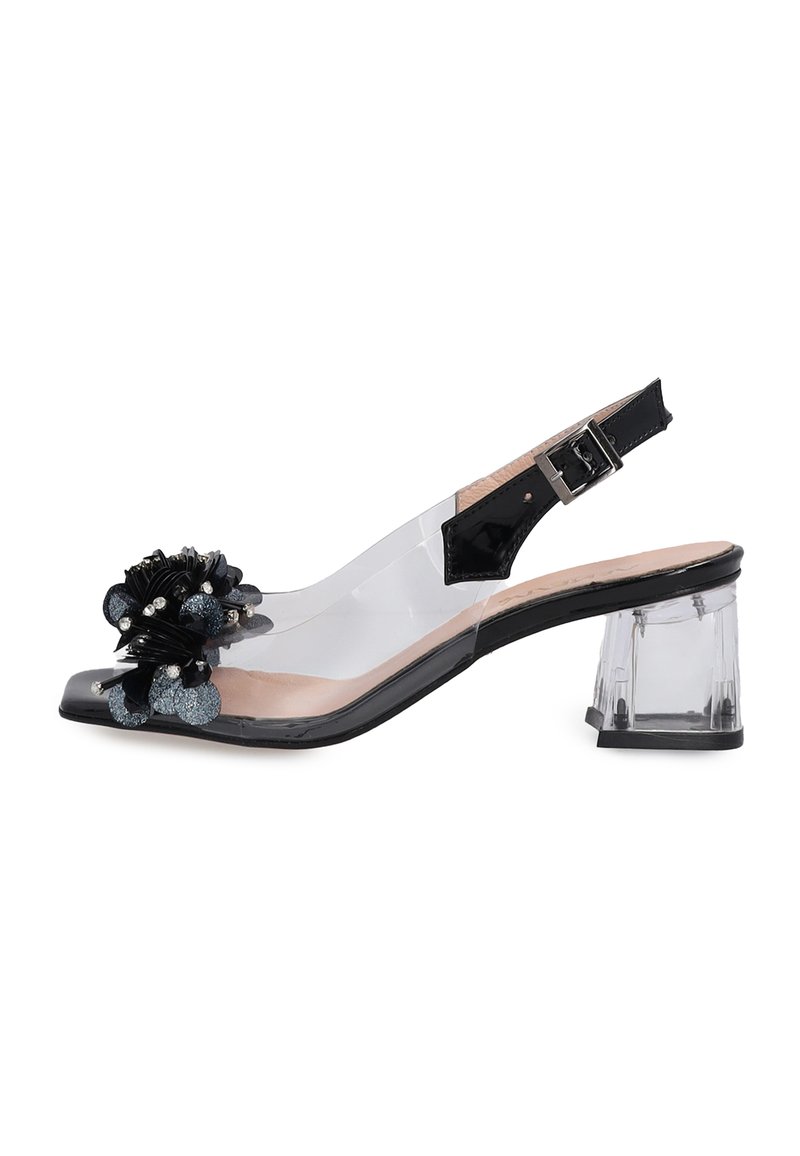 Clear heeled sandal with a transparent upper, black floral embellishment, and ankle strap. Square toe and 3-inch block heel.