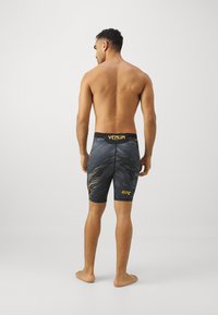 Venum UFC AUTHENTIC FIGHT NIGHT MENS VALE TUDO SHORTS - Punčochy - black/gold