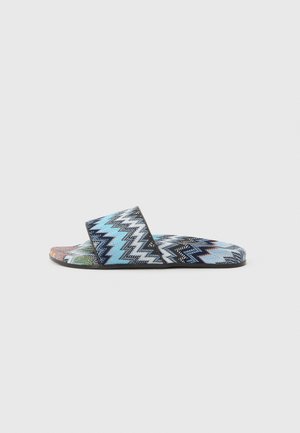 Sandale à enfiler avec motif en zigzag aux couleurs bleu, noir, blanc et vert, dotée d'une large bride en tissu et d'une semelle plate.