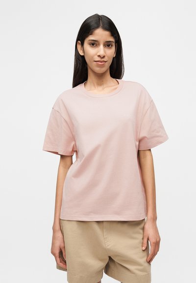 Ροζ βαμβακερό T-shirt με στρογγυλή λαιμόκοψη και κοντά μανίκια. Διαθέτει μινιμαλιστικό σχέδιο χωρίς εμφανή μοτίβα ή γραφικά.