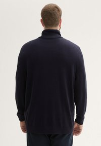 Suéter de punto azul marino con cuello alto, mangas largas y textura suave, con ribetes en el dobladillo y puños.