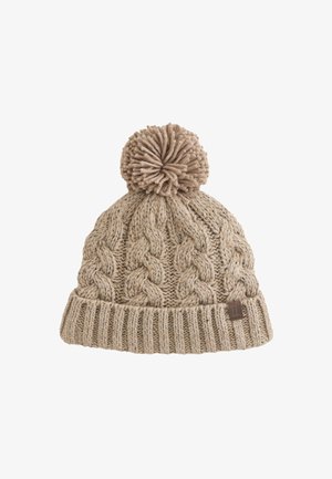 Beežist kootud talvemüts paksude palmikmustritega, voltitud soonilise äärega ja suure pomponiga üleval.