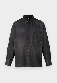 Camicia in denim scuro con bottone frontale, colletto a punta, taschino singolo sul petto e maniche lunghe. Presenta cuciture visibili e un fit rilassato.