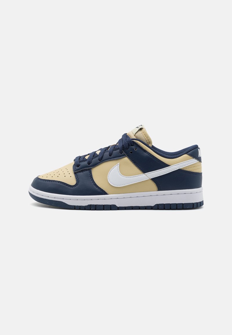 Sneakers Nike Dunk Low caratterizzati da una combinazione di pelle blu navy, gialla e bianca. Punta perforata, design con lacci e suola in gomma.