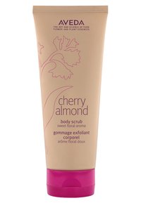 Aveda Cherry Almond body scrub in een beige knijptube met een roze dop. Bevat tekst in paars, met bloemontwerpelementen.