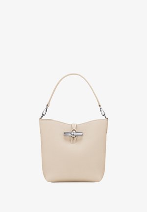 Beige textured handbag with a short handle, clasp closure, and a sleek, minimalistic design. Features a subtle logo accent on the front.